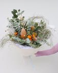 A large size seasonal native flower arrangement. The arrangement pictured features eucalyptus foliage, hakea flowers, a variety of banksias, native daisies, strawflower and zig zag wattle. The bouquet is wrapped in white paper and is tied with a baby blue ribbon.