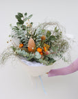 A large size seasonal native flower arrangement. The arrangement pictured features eucalyptus foliage, hakea flowers, a variety of banksias, native daisies, strawflower and zig zag wattle. The bouquet is wrapped in white paper and is tied with a baby blue ribbon. 