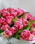 A closeup of a bouquet of bright pink double tulips